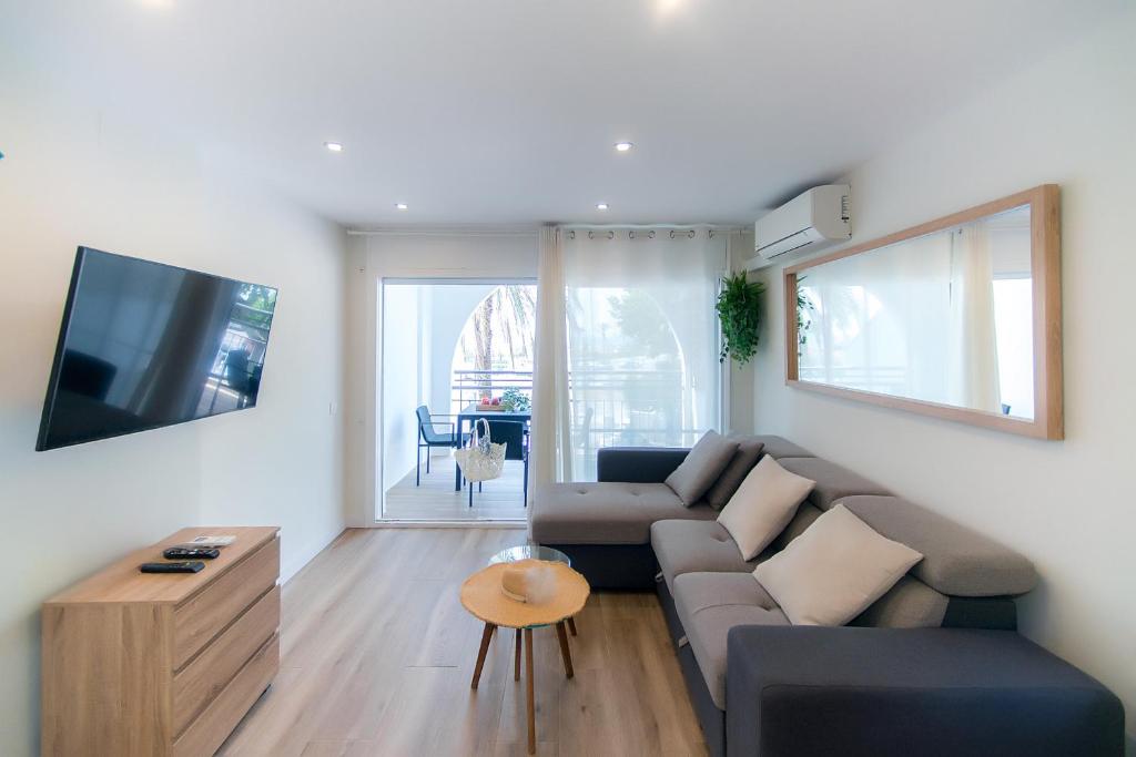 a living room with a couch and a tv at WELCS APARTAMENTO 251 EMP frente al mar in Empuriabrava