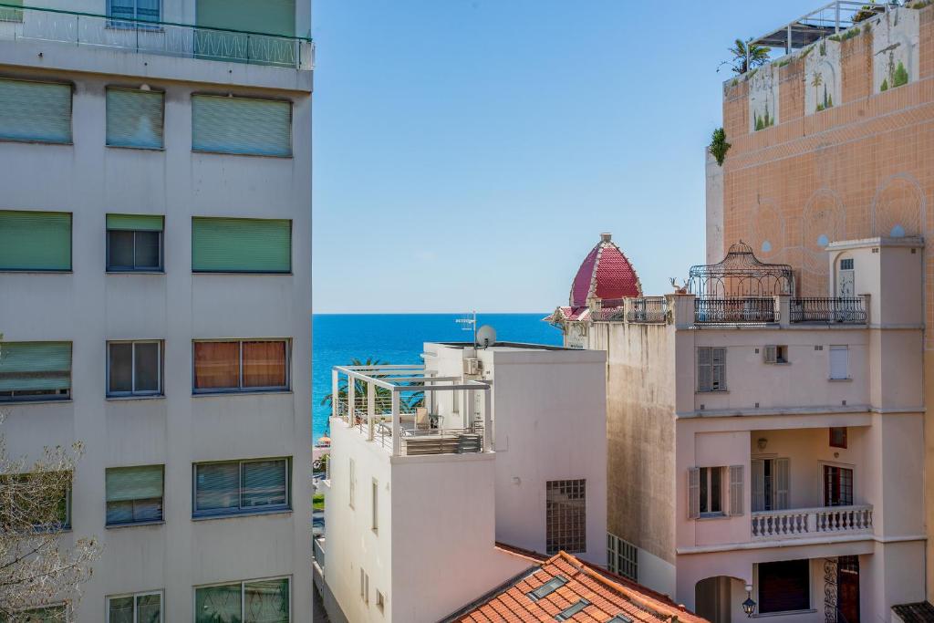 Vue des bâtiments avec l'océan en arrière-plan dans l'établissement LES CARAIBES AP4473 by Riviera Holiday Homes, à Nice