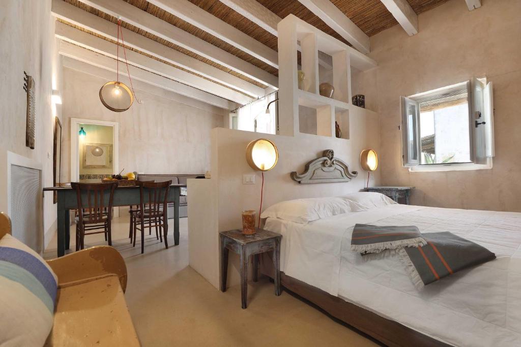 a bedroom with a bed and a dining room at Masseria Borgo Sentinella in Torre dell'Orso