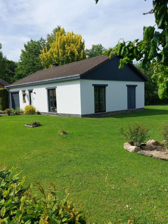 a white and black house with a yard at La Casa Bianca gîte 4 pers in Lierneux