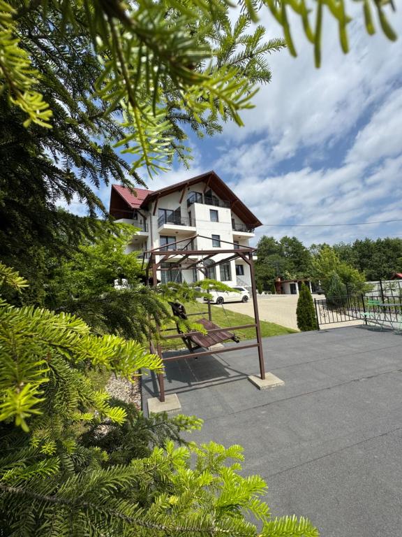 a white house with a playground in front of it at Oana Boutique CDI in Bran