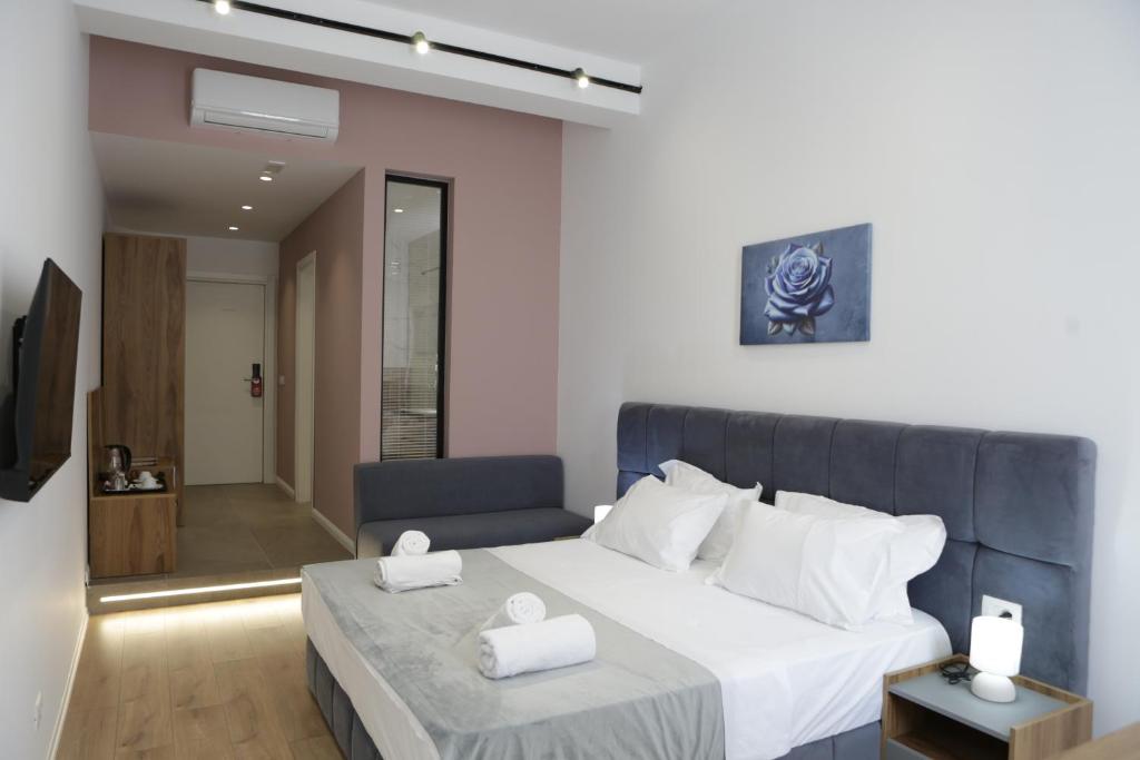 a bedroom with a large bed with two white towels at Hotel La Rosa in Tirana