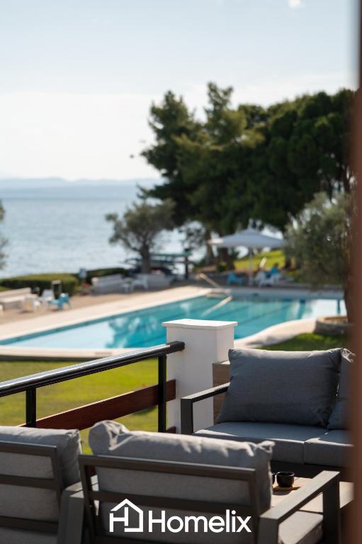 a view of a swimming pool from the balcony of a house at Veya Suite - Private Beach & Pools in Eretria