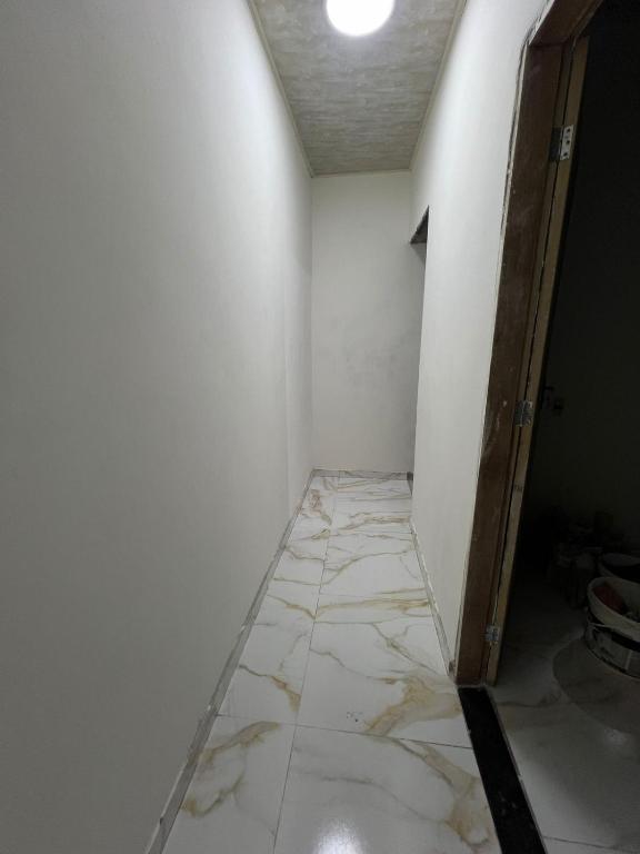 an empty room with a white wall and a tile floor at Acomodação COP30 in Ananindeua