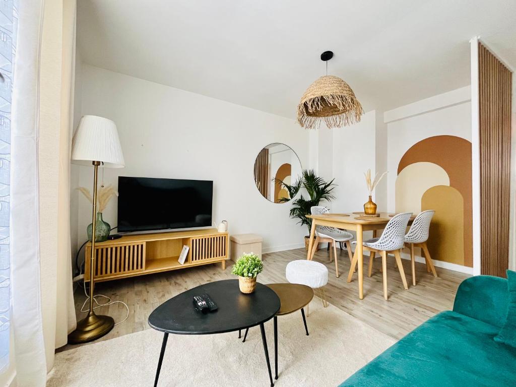 un salon avec un canapé bleu et une table dans l'établissement Le cocon du peintre - Brest centre, à Brest