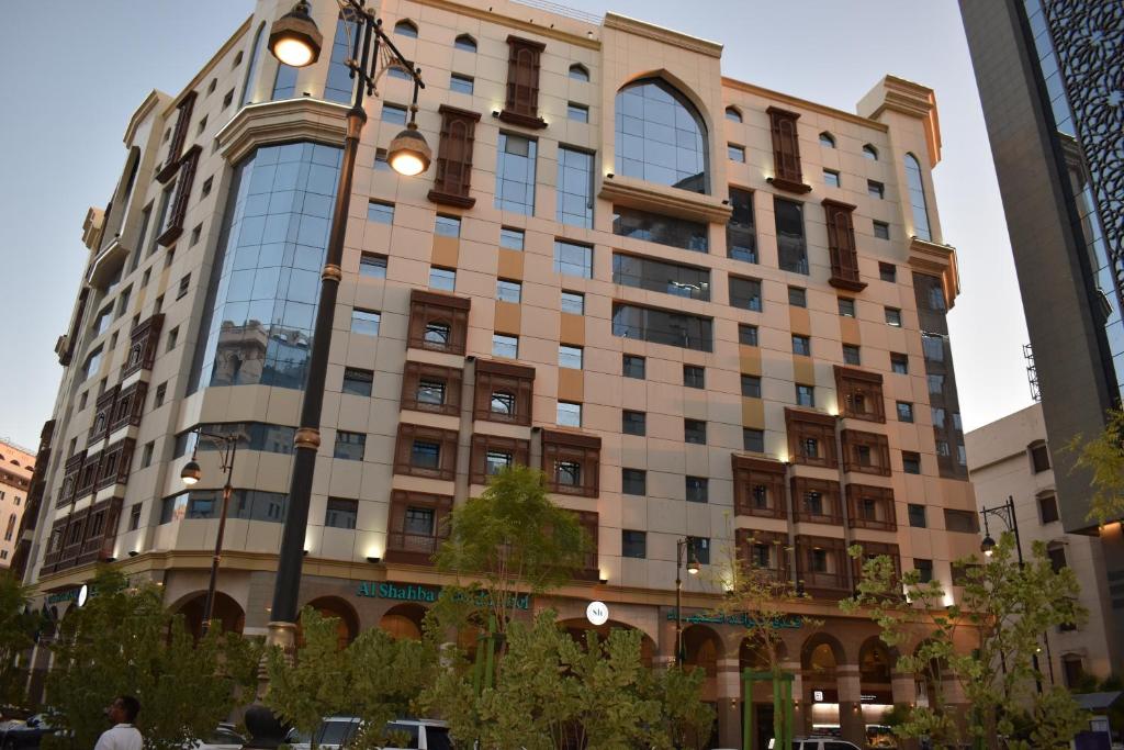 a building with a clock tower on the side of it at جراند الشهباء Grand Alshahba Hotel in Al Madinah
