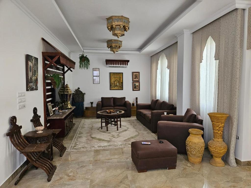 a living room with couches and a table at Duplex in El Sherouk next to Madinty دوبلكس بحديقة خاصة مدينة الشروق in Madīnat ash Shurūq