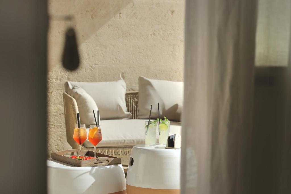 a living room with a couch and two tables with drinks at Masseria Borgo Sentinella in Torre dell'Orso