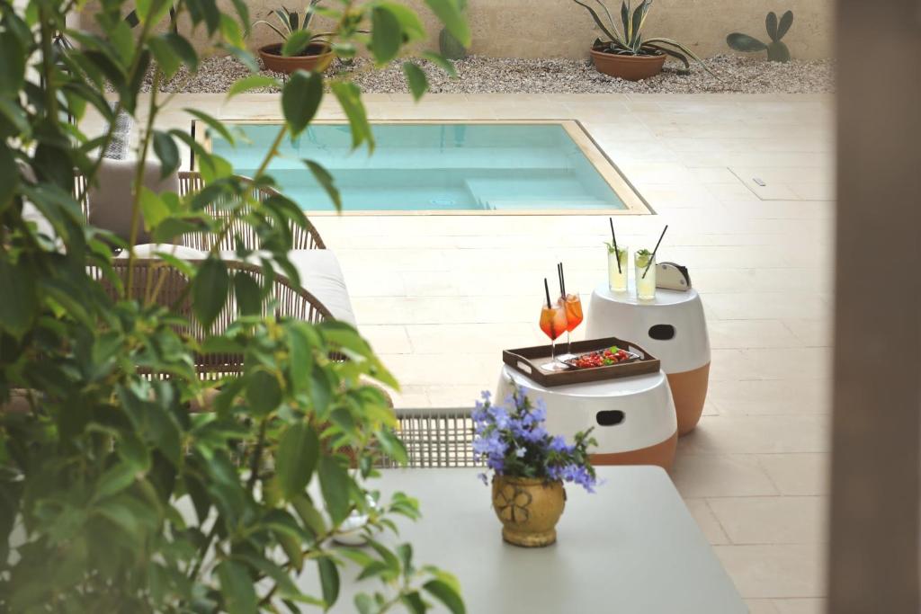 a patio with a pool and a table with plants at Masseria Borgo Sentinella in Torre dell'Orso