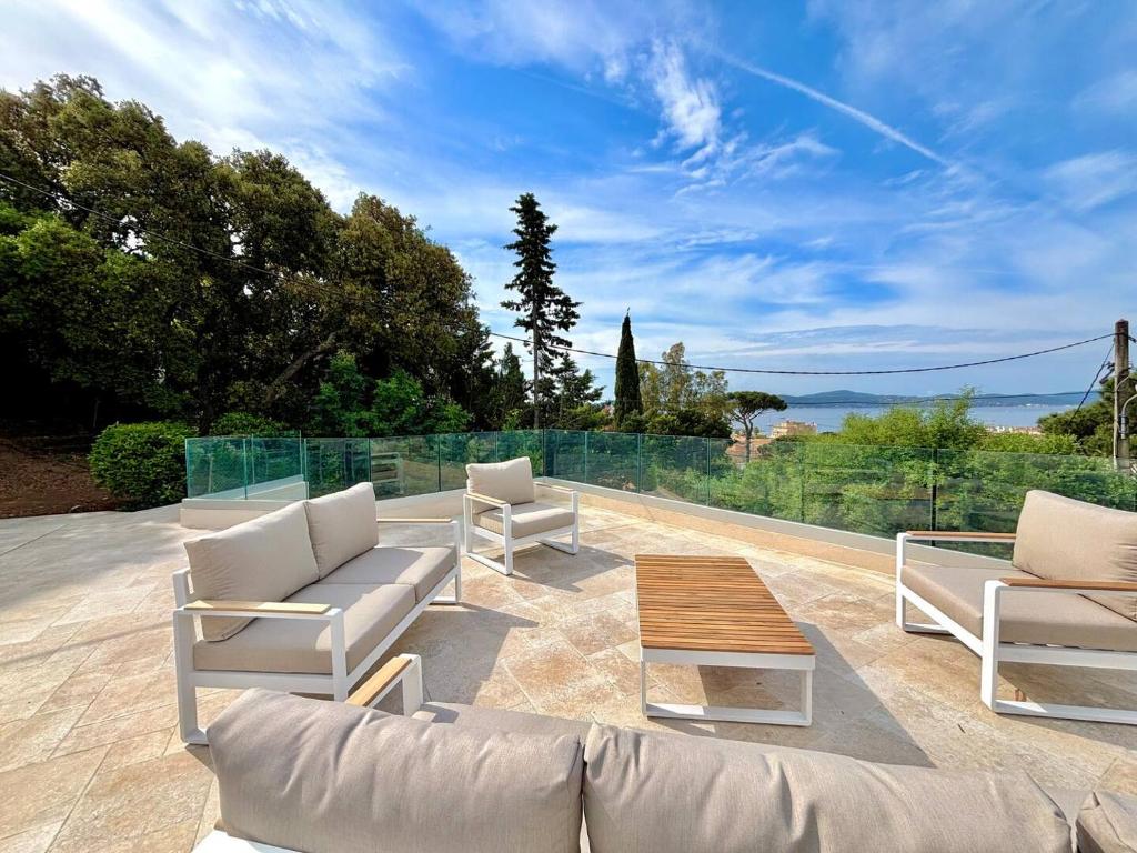 d'une terrasse avec 2 chaises blanches et une table basse. dans l'établissement villa capricorne, à Sainte-Maxime