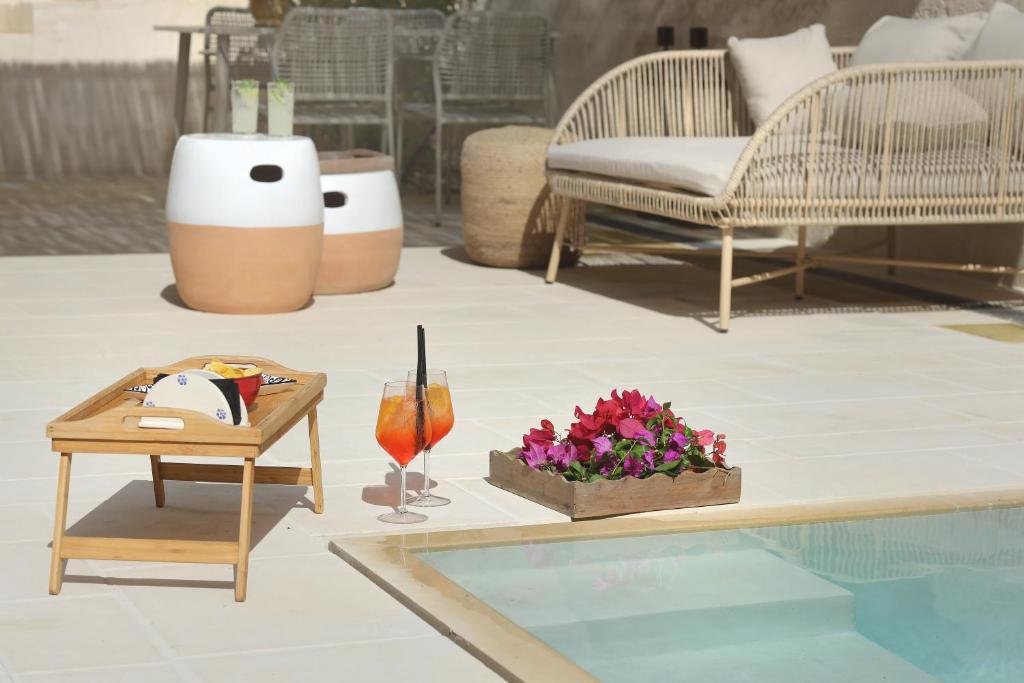 a living room with a table with flowers and a drink at Masseria Borgo Sentinella in Torre dell'Orso