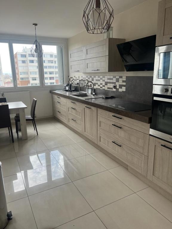 une cuisine avec un évier et une table à l'intérieur dans l'établissement Moderne 3 Pièces proche métro et tram, à Villeurbanne