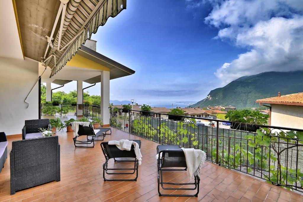 a balcony with chairs and a view of a mountain at Appartamento Casa Ledio - Theater Home in Tignale