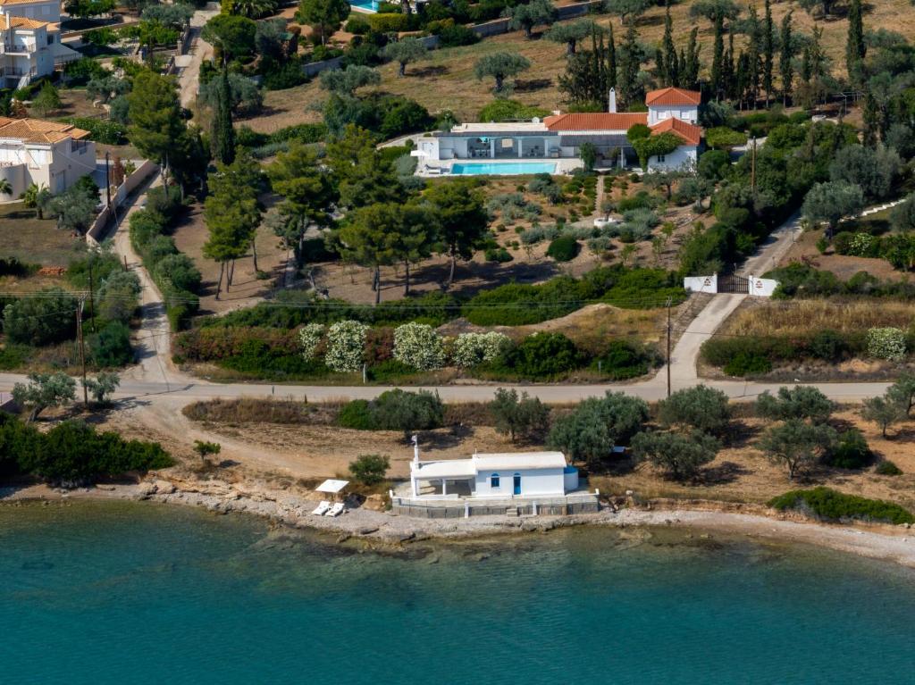 an aerial view of a house on an island in the water at Villa Seascape, Beachfront Living in the Greek Riviera Porto Heli in Porto Heli