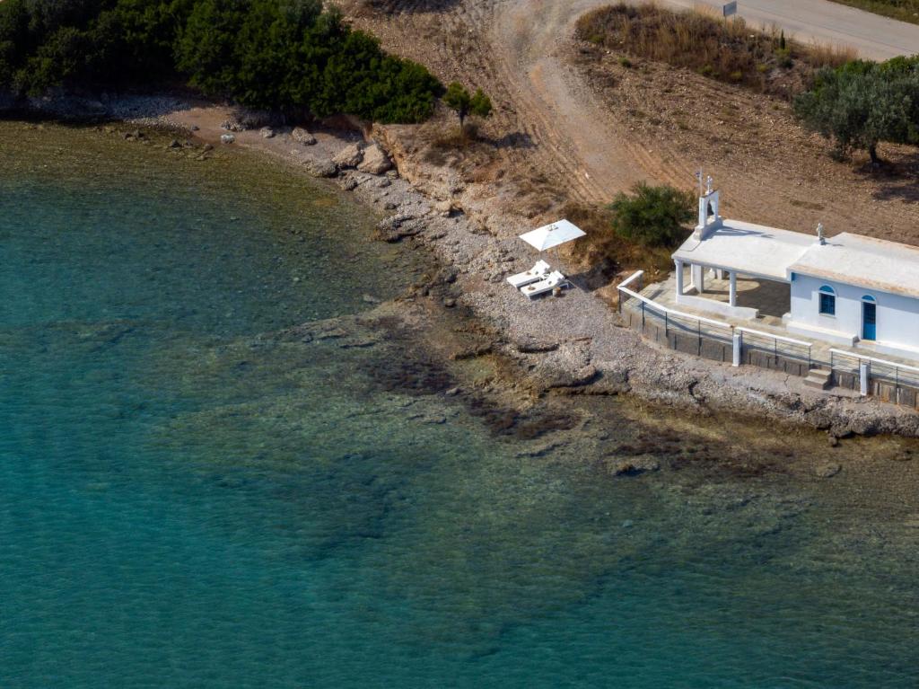 an aerial view of a house next to the water at Villa Seascape, Beachfront Living in the Greek Riviera Porto Heli in Porto Heli