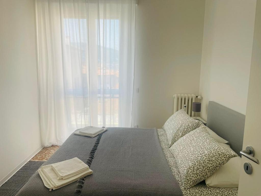 a bed in a bedroom with a large window at Baveno Lakeview Escape in Baveno