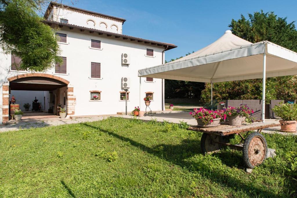 Un edificio blanco con una mesa con una sombrilla blanca. en Mono Garden Colombare Teboi, en Lazise