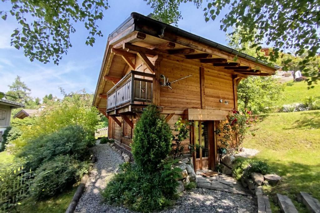 une cabane dans les bois avec un balcon dans l'établissement Beautiful chalet with garden close to the slopes, à Megève