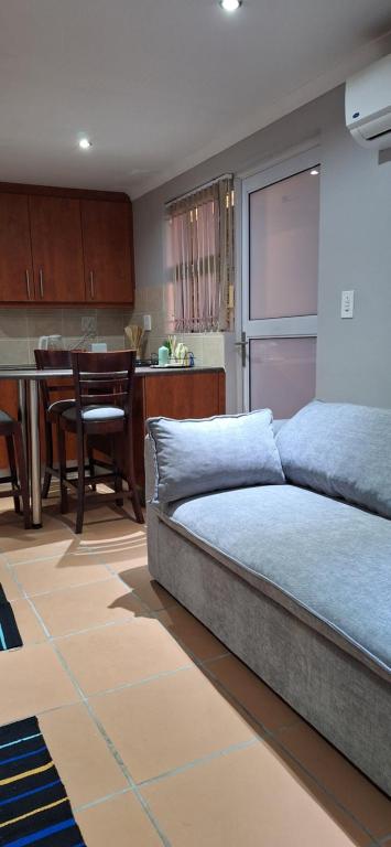 a bedroom with a bed and a kitchen with a table at Firehouse selfcatering Garden Cottages no 5 in Wellington