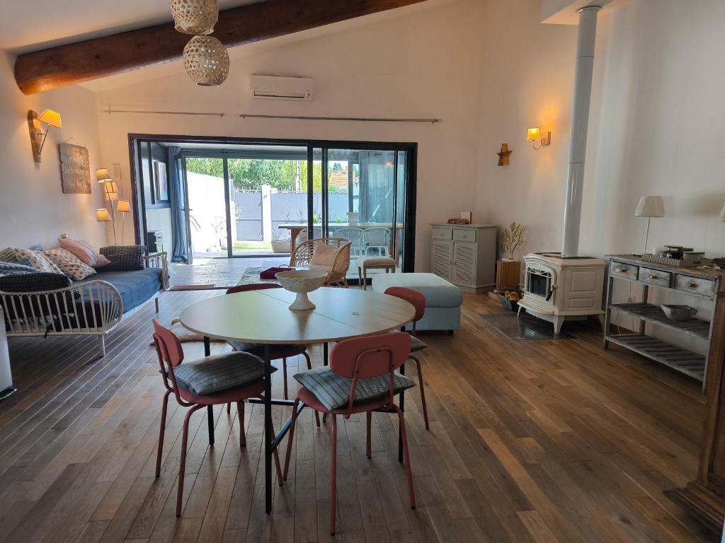 a living room with a table and chairs at Ma maison aux Angles calme climatisée in Les Angles Gard