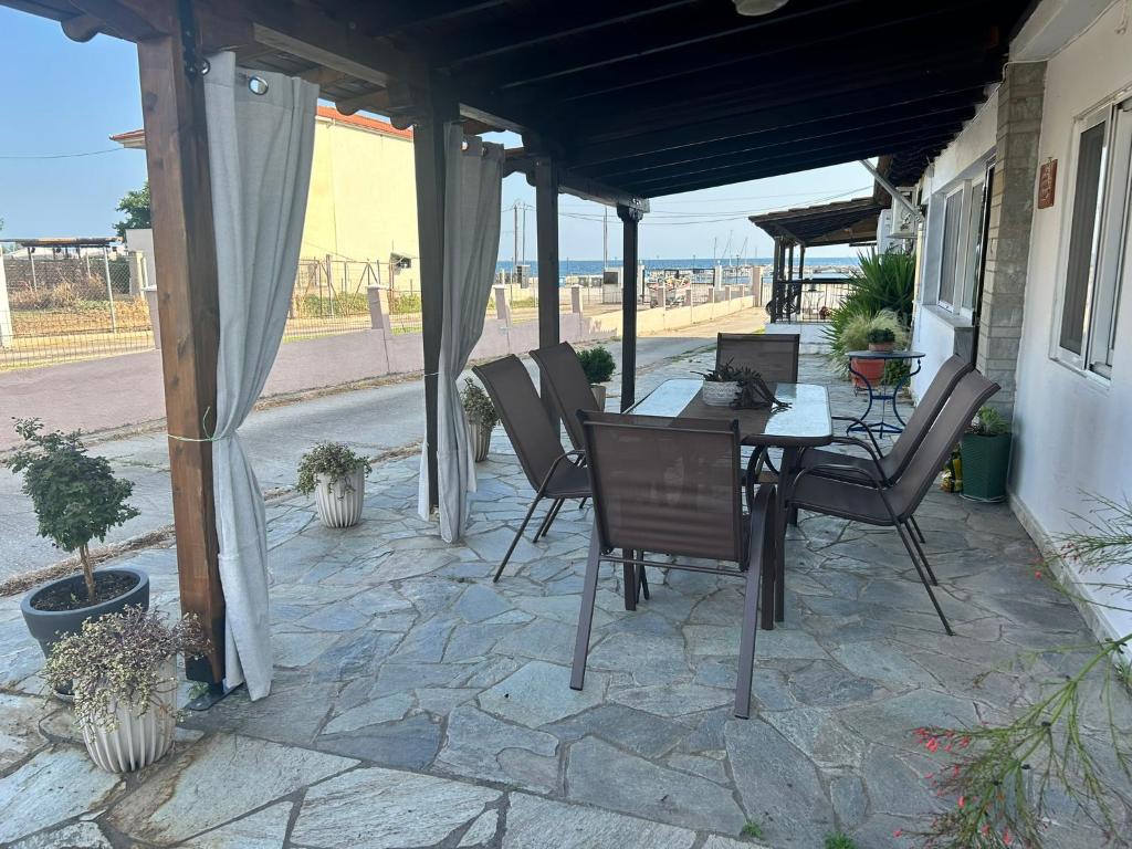 a patio with chairs and a table with a laptop on it at Evangeo Seaview Apartment Epanomi in Epanomi