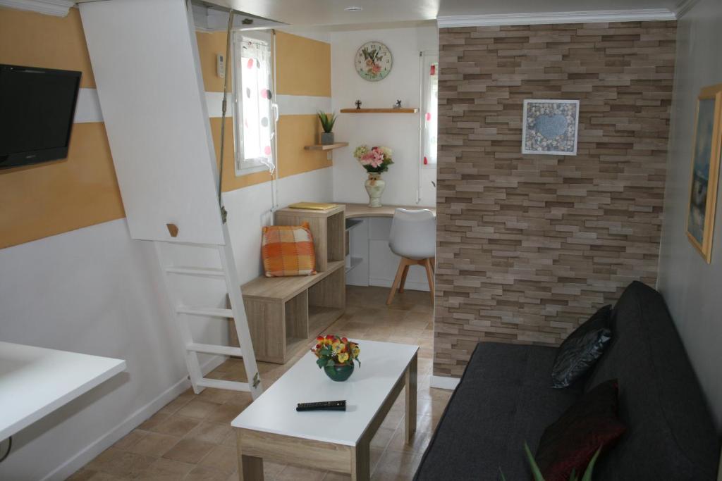 un petit salon avec un canapé et une table dans l'établissement Phil34, à Valergues