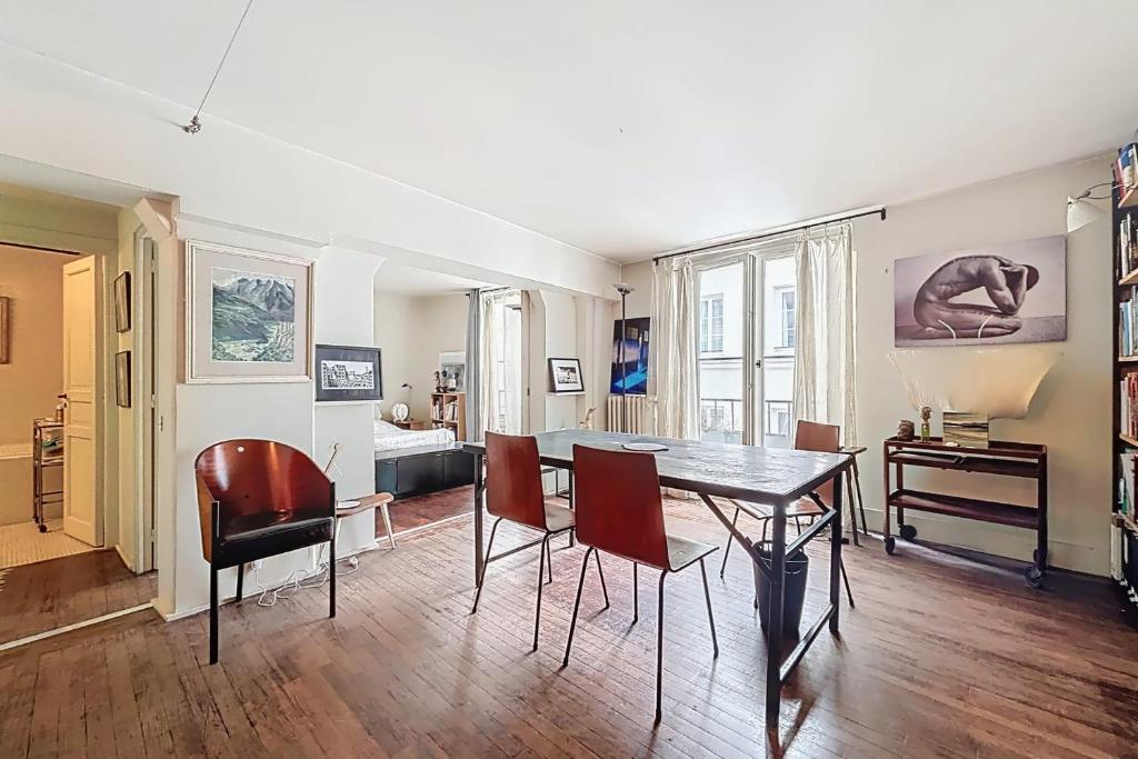 un salon avec une table et des chaises de salle à manger dans l'établissement Cosy apartment near Bastille, à Paris