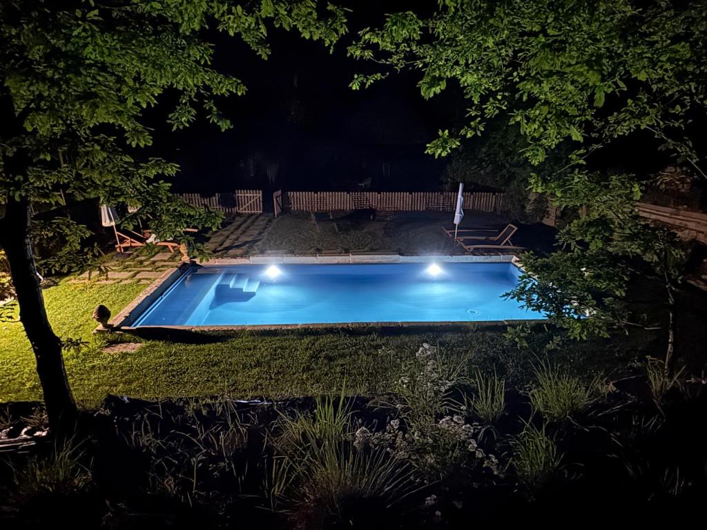a swimming pool in a yard at night at Domaine du tertre ychot in Dol-de-Bretagne