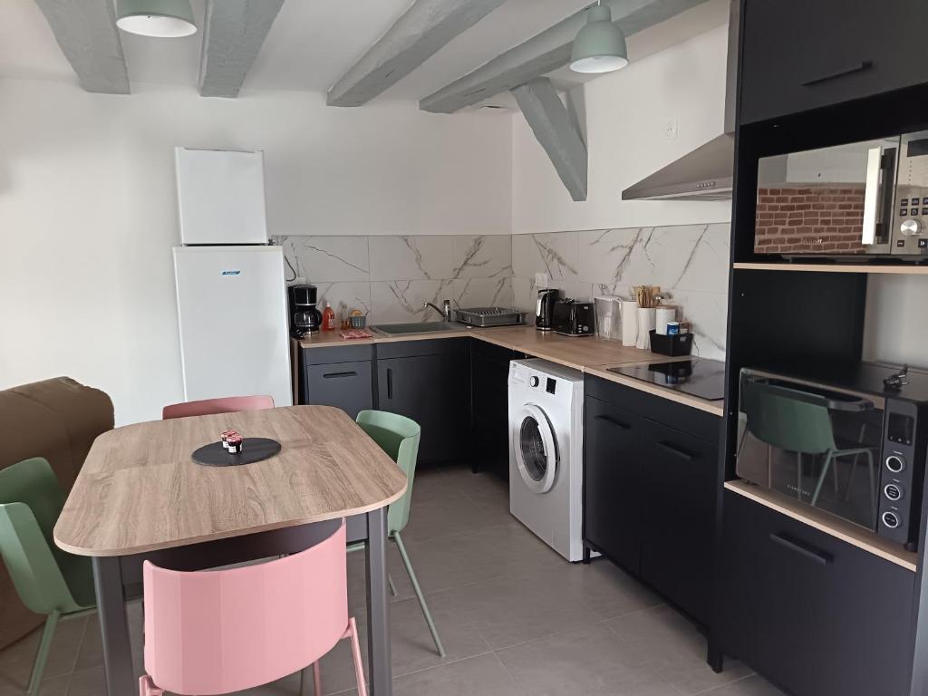 - une cuisine avec une table, une table et des chaises dans l'établissement Ferme de la Dalbeine, à Veuzain-sur-Loire