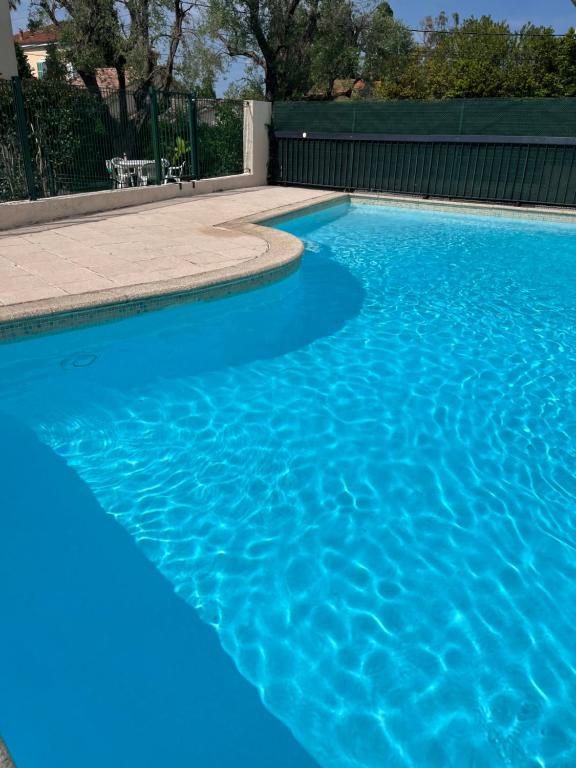 une piscine avec de l'eau bleue dans une cour arrière dans l'établissement Exclusive 80 sqm apartment with private garden and terrace on the Cap d Antibes, 300 mt from sandy Plage de la Salis, à Antibes