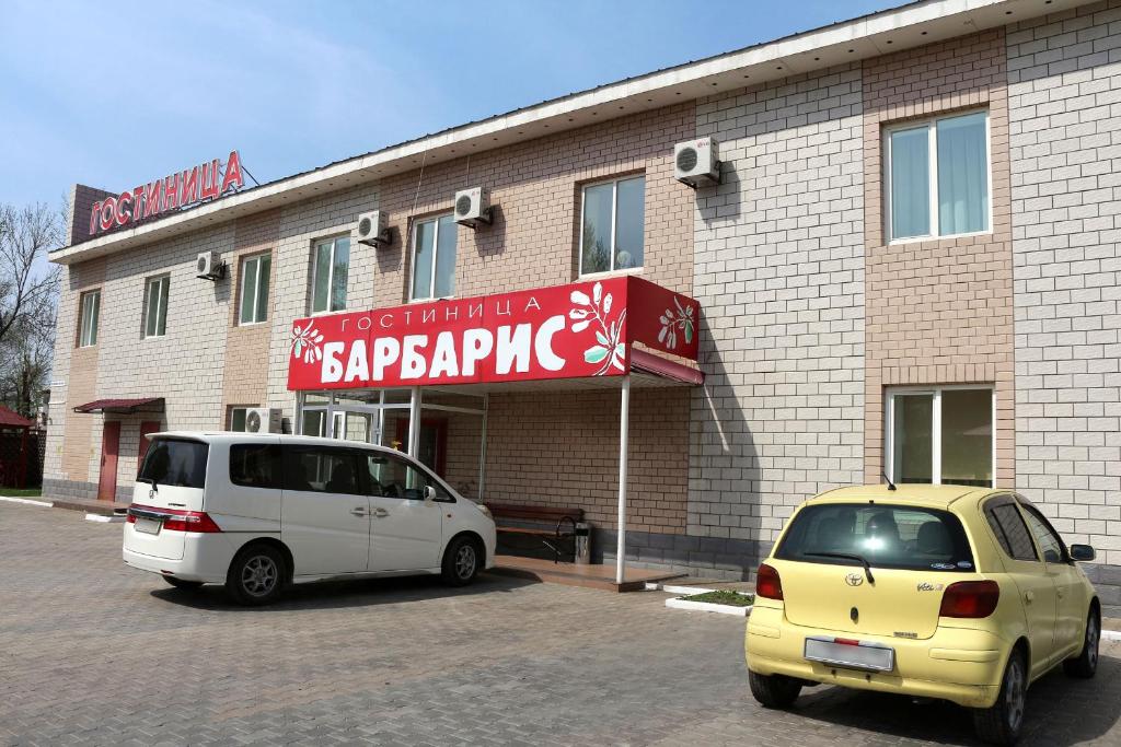 two cars parked in a parking lot in front of a building at Barbaris in Birobidzhan