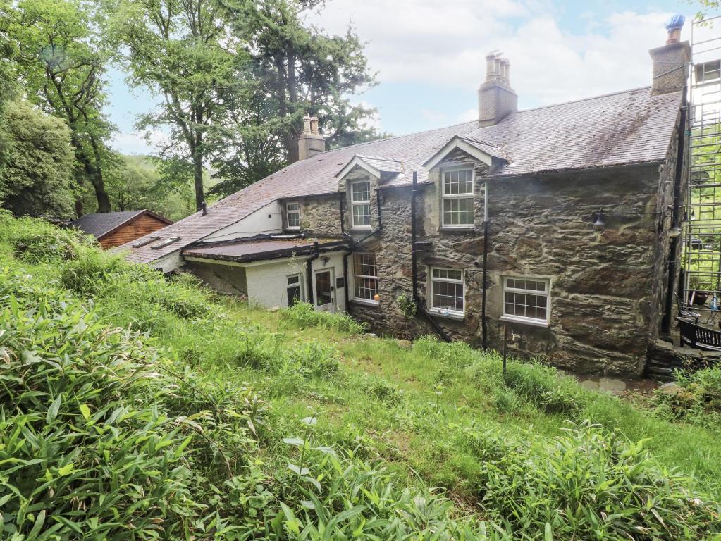 an old stone house on the side of a hill at Sygun Cottage in Caernarfon