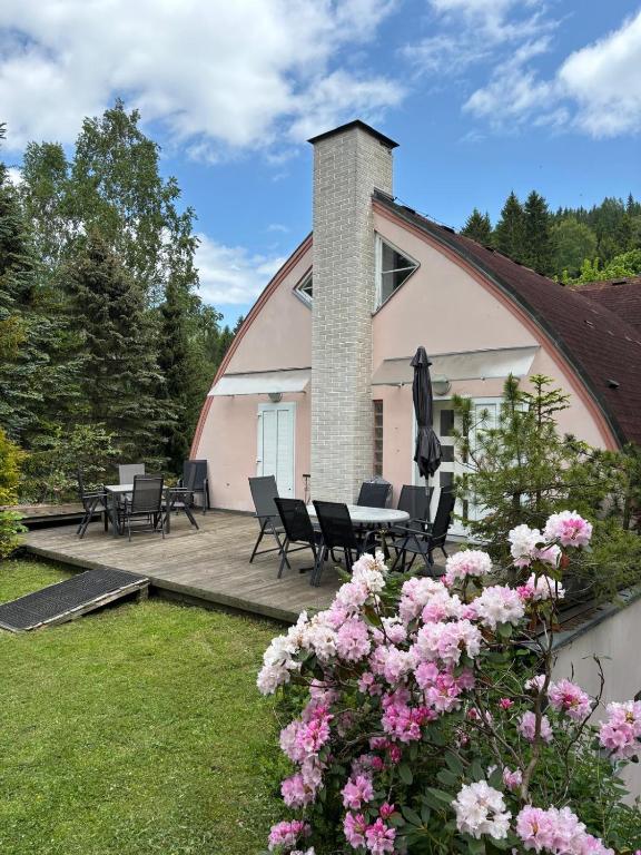 a house with a patio and flowers in the yard at Apartmány Holiday Pec in Pec pod Sněžkou