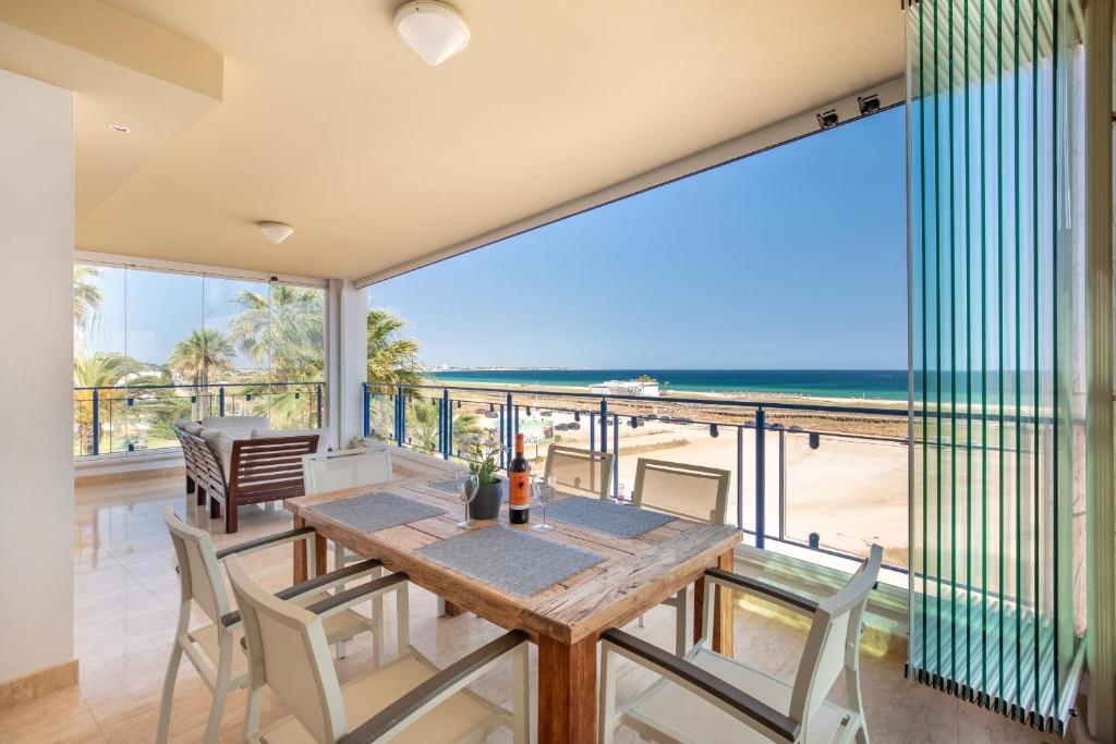 a dining room with a table and views of the beach at 426 Casa Onda Mirabaia in Albardeira