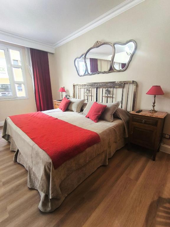 a bedroom with a large bed with a red blanket at Tanguero Hotel Boutique Antique in Buenos Aires