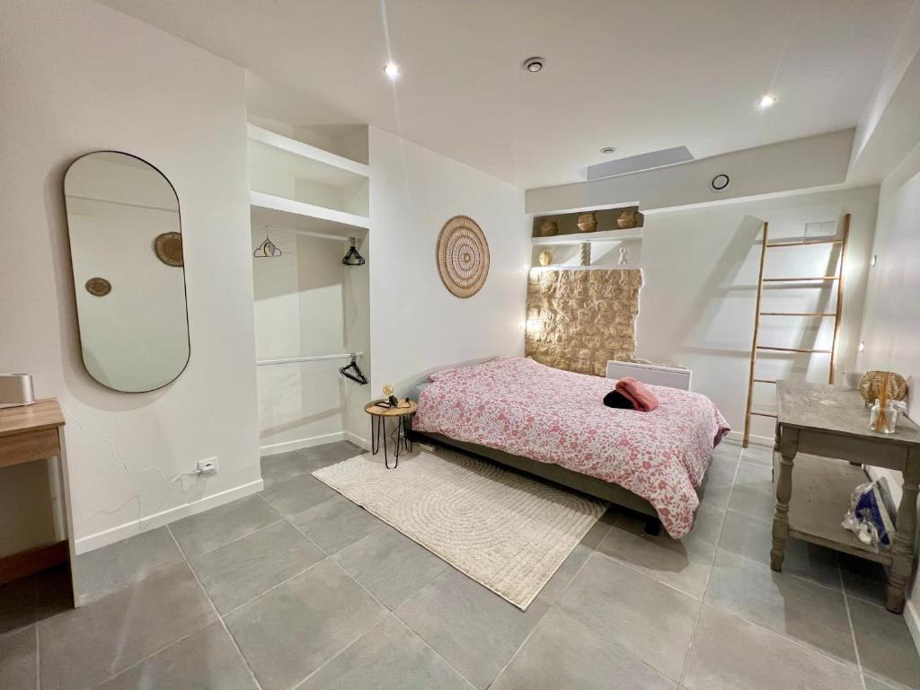 - une chambre avec un lit rose et un miroir dans l'établissement La Tranchée, à Poitiers