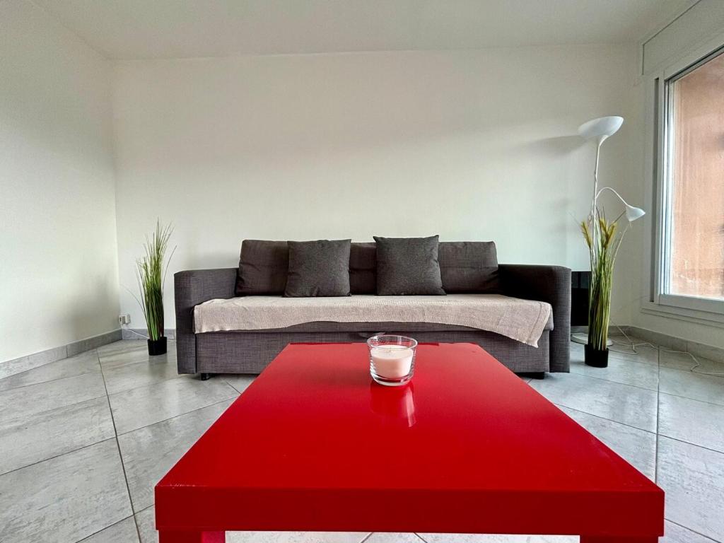 - un salon avec une table rouge et un canapé dans l'établissement Une parenthèse sur l'eau, à Marseille