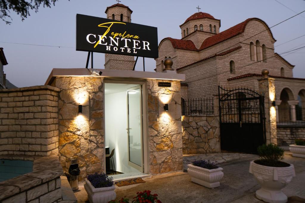 a building with a sign for a center hotel at Tepelena Center Hotel in Tepelenë