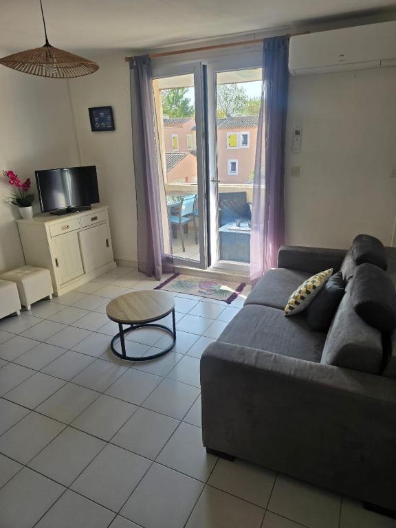 un salon avec un canapé et une table dans l'établissement Appartement bord de mer, à Le Castellas