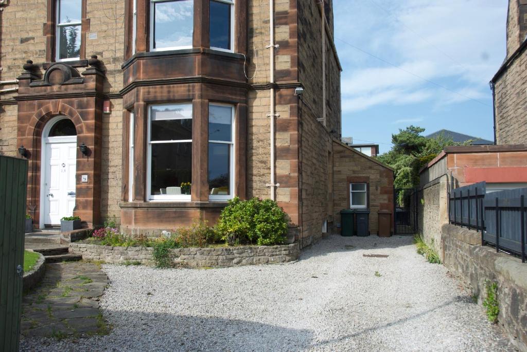 an external view of a brick house with a driveway at Victorian Apartment with car parking in driveway, Murrayfield in Edinburgh