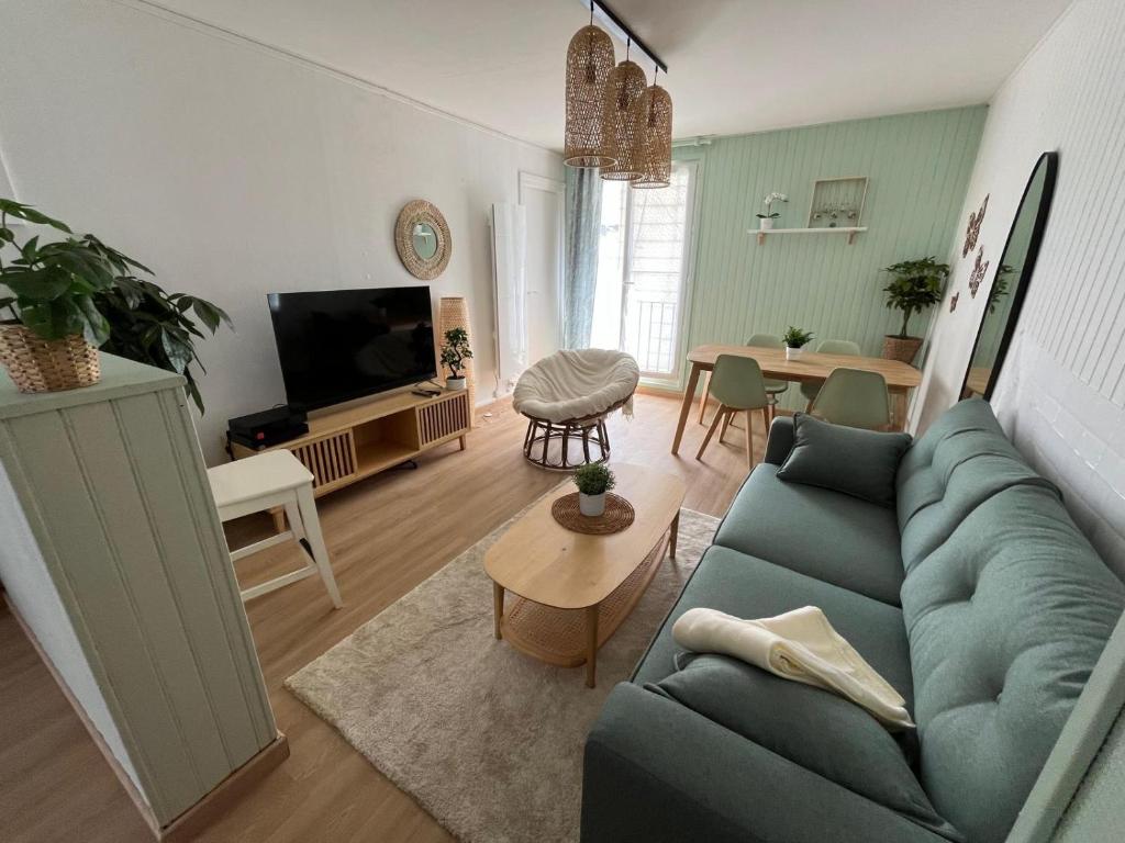 un salon avec un canapé bleu et une table dans l'établissement Le cocon de Saint Mart'inn, à Brest