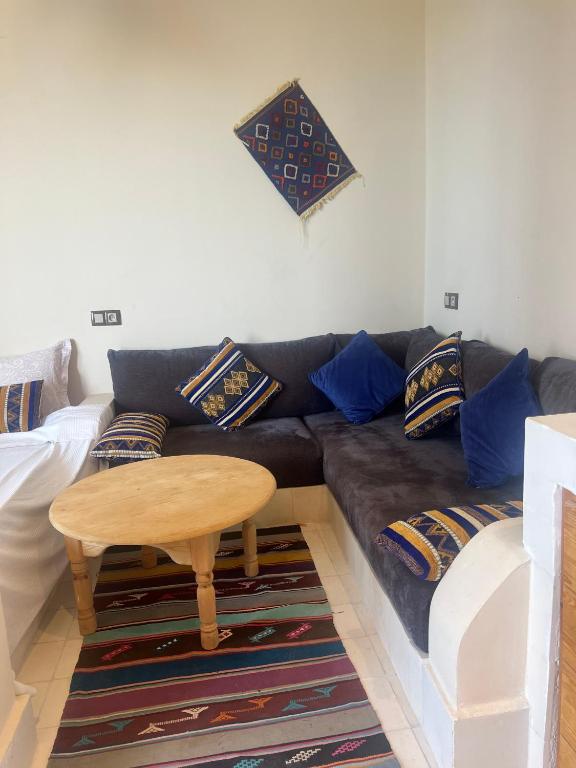 a living room with a couch and a table at SurfAppart Morocco in Tamraght Ouzdar
