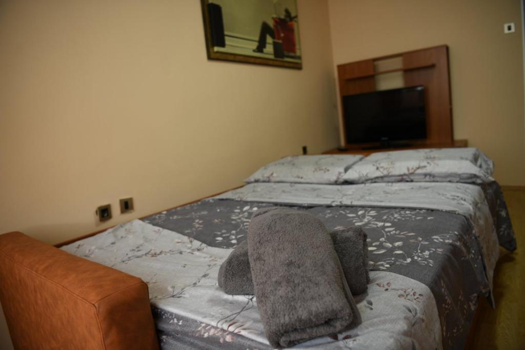 Un dormitorio con una cama con una silla encima. en Stan Centar, en Bitola