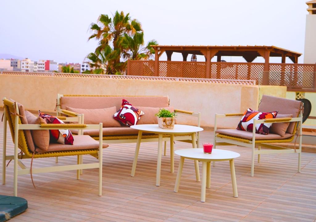 a patio with chairs and tables on a roof at Villa Sable de Mirleft Luxury Apartment in Mirleft