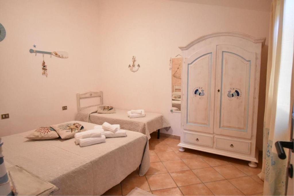 a room with two beds and a cabinet with towels at Villa Venere in Domus de Maria