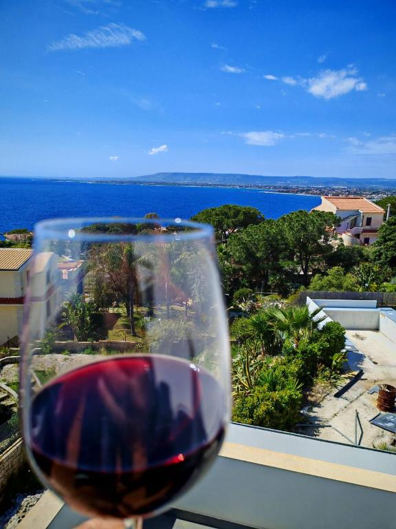 a glass of wine with a view of the ocean at Villa Plemmirio Reserve in Plemmirio