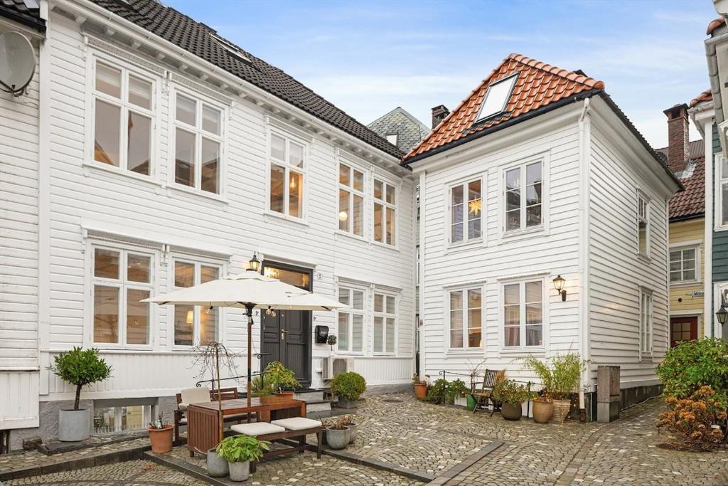 un cortile con edifici bianchi e un ombrellone di Historic House City Centre a Bergen