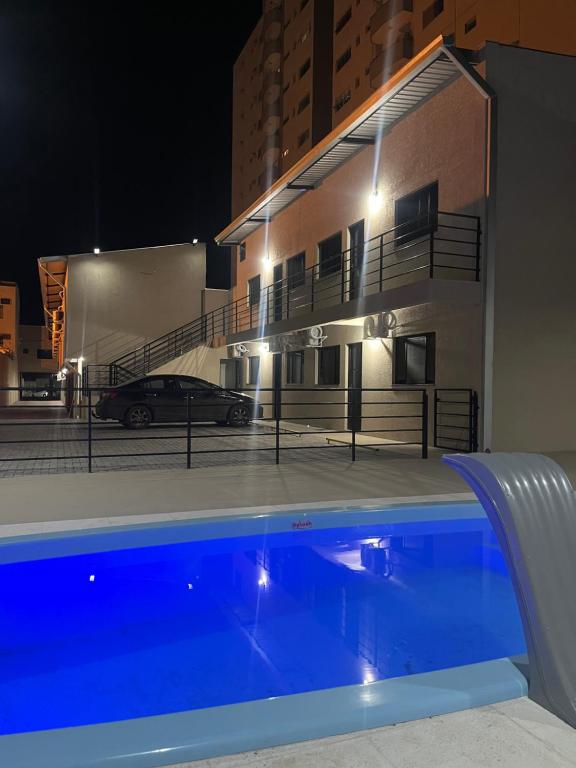 a swimming pool in front of a building at night at Condomínio Diamond - Novo - Centro in Corumbá