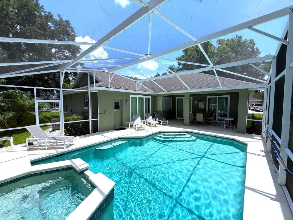 ヘインズ・シティにあるGolf Course Views Large Pool Deck Villa in Southern Dunesの家の上にパーゴラ付きのスイミングプール