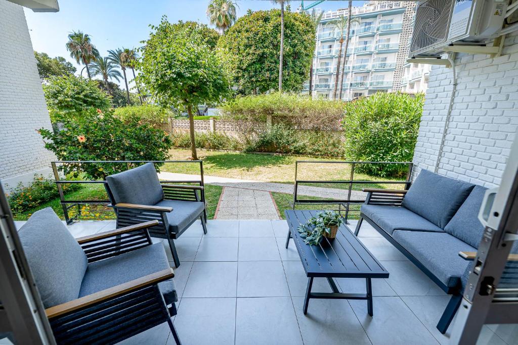 a patio with couches and a table and chairs at Benalmádena Puerto Marina Vacation Apartment 1 minute from the beach in Benalmadena Costa